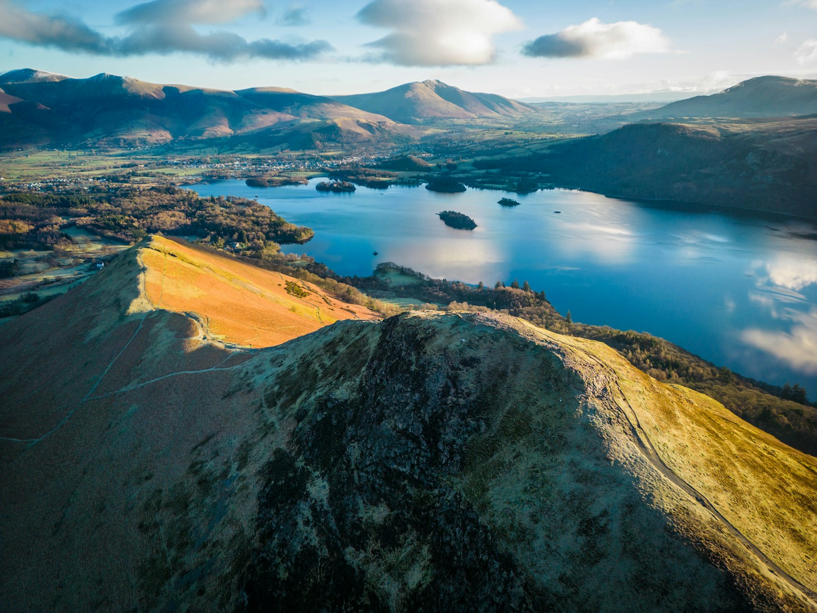 an aerial view of a lake surrounded by mountains